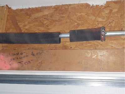 Broken garage door torsion spring that needs repair